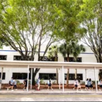 Students walking along the covered walkway outside the school building.